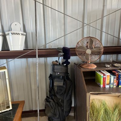 Sale Photo Thumbnail #42: Collection of household items including a black golf stand bag with clubs, a copper-toned table fan, and decorative white buckets.