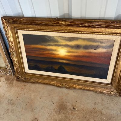 Sale Photo Thumbnail #60: Framed oil painting depicting a dramatic sunset over water with a flying bird, housed in an ornate carved gold-tone frame with a fabric liner.