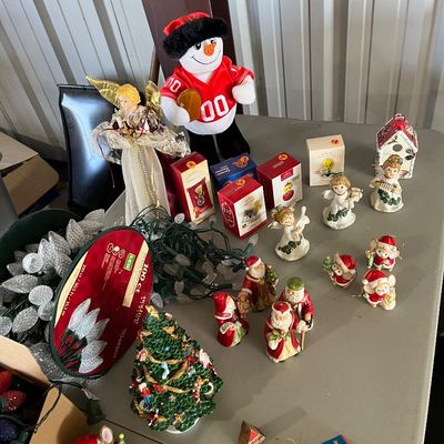 Sale Photo Thumbnail #33: Collection of holiday decorations, including an angel tree topper, plush football snowman, miniature ceramic figurines, and boxed LED Christmas lights.