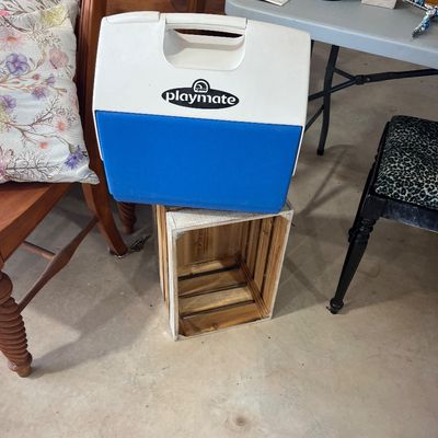 Sale Photo Thumbnail #9: Vintage Igloo Playmate blue and white portable cooler resting on a small wooden crate.