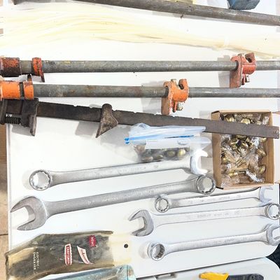 Sale Photo Thumbnail #30: Assortment of workshop tools and hardware including pipe clamps, large combination wrenches, a vintage Craftsman electric engraver, pop rivet tool, and brass cabinet knobs.
