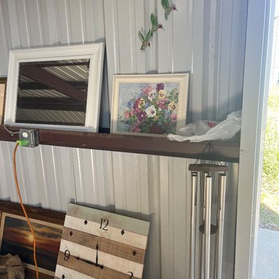 Sale Photo Thumbnail #80: Collection of home decor items including a square wooden wall clock, a set of metal wind chimes, framed wall art, and a white mirror.