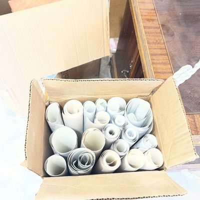 Sale Photo Thumbnail #66: Cardboard box packed with various rolled paper rolls, prints, or drafting sheets.
