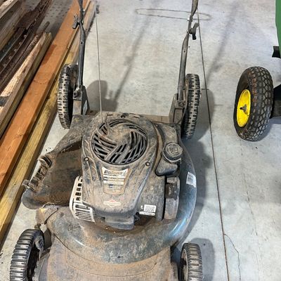 Sale Photo Thumbnail #18: Bolens push lawn mower powered by a Briggs & Stratton engine, showing heavy dust and cosmetic wear from use.