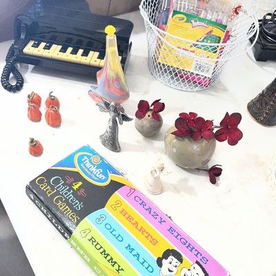 Sale Photo Thumbnail #91: A collection of tabletop items including a ThinkFun children's card games set, small figurines, mini pumpkins, art supplies, and a piano-shaped novelty phone.