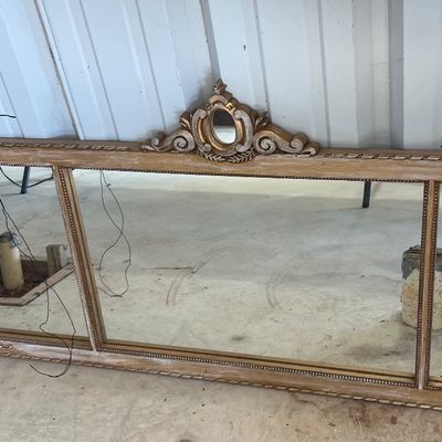 Sale Photo Thumbnail #57: Large vintage three-paneled dresser mirror featuring a whitewashed wooden frame with a decorative gilded scroll crest.