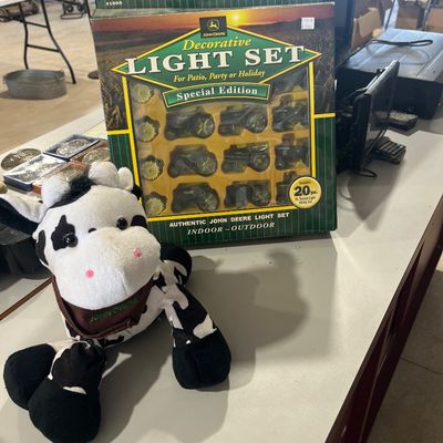 Sale Photo Thumbnail #71: John Deere special edition 20-piece decorative light set in original box, paired with a plush John Deere cow toy.