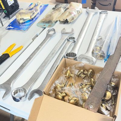 Sale Photo Thumbnail #12: Collection of large industrial combination and open-end wrenches, hand tools, wire strippers, and a box of brass cabinet hardware.