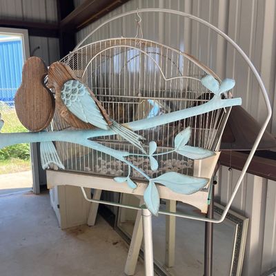 Sale Photo Thumbnail #76: Vintage wire birdcage mounted on a metal stand, paired with a distressed light blue and carved wood decorative bird wall branch sculpture.