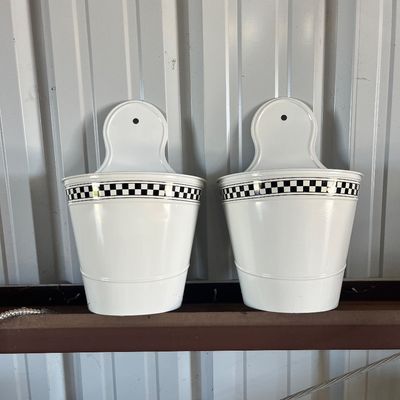 Sale Photo Thumbnail #41: Pair of white metal wall-hanging planters featuring a black-and-white checkered trim along the top rim.