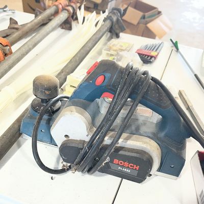 Sale Photo Thumbnail #2: Bosch model PL1632 corded electric hand planer, showing moderate wear and sawdust from previous use.