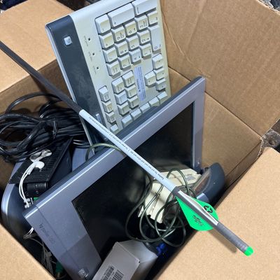Sale Photo Thumbnail #134: Cardboard box containing vintage computer accessories, including an HP Pavilion f1503 monitor, a computer keyboard, cords, and an archery arrow.