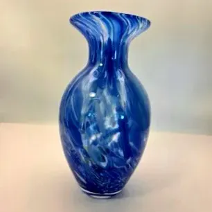 Hand-blown art glass vase featuring swirls of cobalt blue and white with a flared rim.