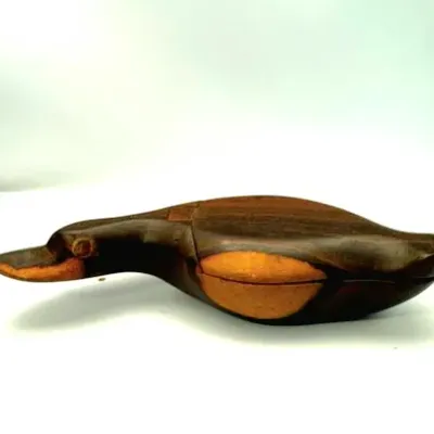 Hand-carved wooden duck decoy box with two-tone finish and articulated wing detail.