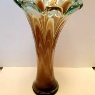 Vintage art glass vase featuring a ruffled rim and a swirled amber and white body encased in clear glass.
