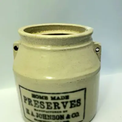 Antique beige stoneware jar with black stenciled lettering reading 'Home Made Preserves Manufactured by H.A. Johnson & Co....