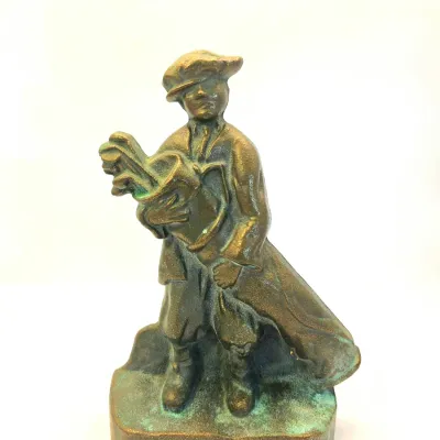 Vintage bronze-finished cast iron or metal caddy figurine, depicting a young boy carrying a golf bag with clubs.
