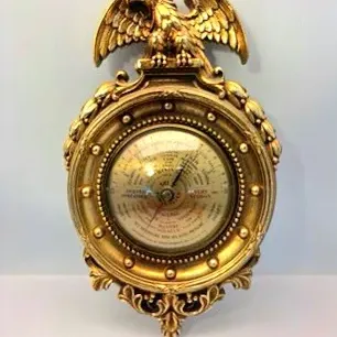 Vintage Airguide brass wall barometer featuring an ornate frame topped with a spread-wing eagle finial.