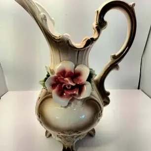 Vintage ceramic pitcher featuring an applied dimensional pink rose and leaf details with ornate scrollwork.