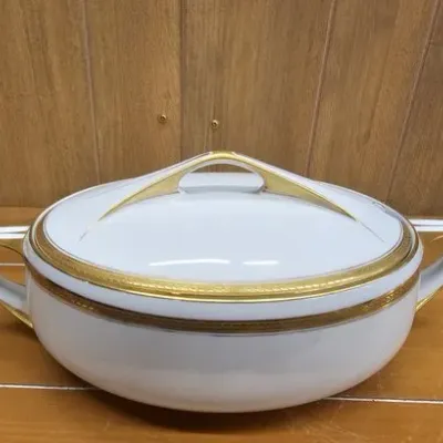 Mid-century fine china covered tureen with ornate gilt trim and a sleek arched lid handle.