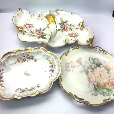 Set of three vintage floral porcelain serving pieces featuring gilded rims and hand-painted rose motifs, including a double-lobed divided...