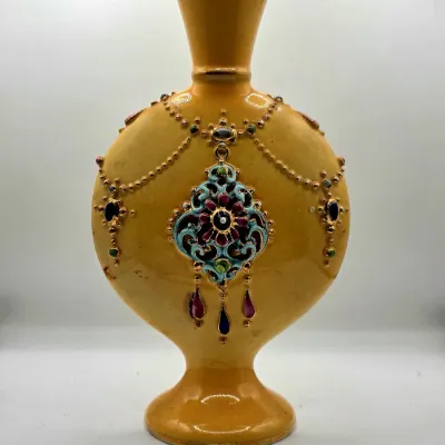 Antique yellow ceramic vessel with raised gilt jewel motifs and polychrome enamel detailing.