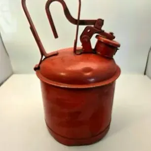 Vintage red Eagle safety gasoline can featuring a top carrying handle and trigger-operated pour spout mechanism.