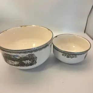 Pair of vintage enamel nesting bowls featuring printed landscape scenes with silver-toned metal trim around the rims.