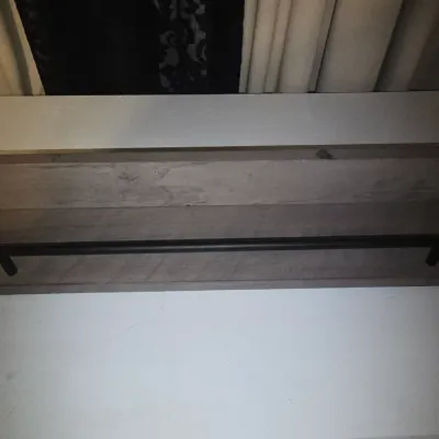 Sale Photo Thumbnail #68: Rustic gray-washed wooden wall shelf featuring a black metal front guard rail with decorative end finials. Designed for holding picture frames, small decor, or spices. Appears to be in good condition with minor surface wear.17"