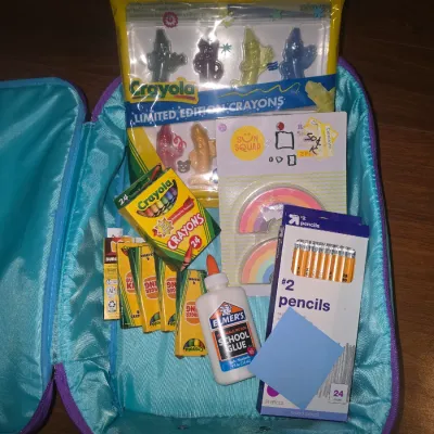 Sale Photo Thumbnail #58: Includes a Disney 100 Years of Wonder rolling suitcase decorated with Princess postage stamp art (Aladdin, Cinderella, The Little Mermaid). Inside comes filled with various art and school supplies including Crayola limited edition character crayons, stand