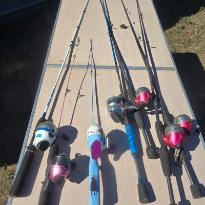 Sale Photo Thumbnail #143: Collection of seven fishing rods equipped with spin-cast reels. Includes themed rods such as Star Wars and Frozen/Disney, alongside adult/standard utility rods. Items show typical signs of outdoor use and wear. Functionality has not been individually test