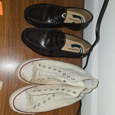 Sale Photo Thumbnail #204: Lot of 2 pairs of men's shoes including:
- Pair of brown leather Nunn Bush Comfort Gel penny loafers.
- Pair of white canvas high-top sneakers (unlaced).

Both pairs show signs of wear consistent with use. Please refer to photos for condition details.