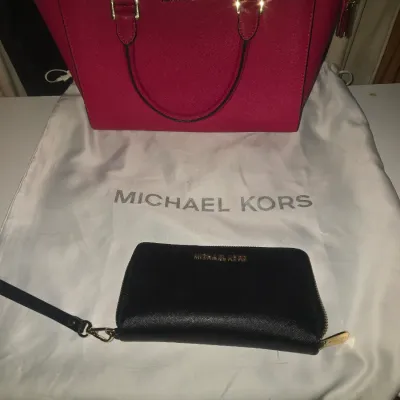 Sale Photo Thumbnail #95: designer handbag set featuring a bright pink/magenta saffiano leather satchel with gold-tone hardware and top handles, a matching black zip-around wristlet wallet, and a white branded dust bag. Items appear to be in good condition with light signs of wear