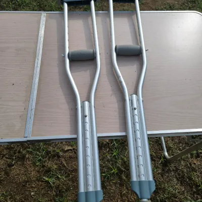 Sale Photo Thumbnail #177: Pair of lightweight, height-adjustable aluminum underarm crutches with rubber tips, handgrips, and underarm pads. Features push-button height adjustment mechanisms.