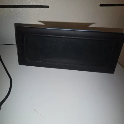 Sale Photo Thumbnail #31: Black plastic rectangular digital clock or display unit. Includes attached usb power cable. Shows minor surface wear and dust, unverified functionality.
