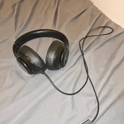 Sale Photo Thumbnail #197: Pair of black Beats by Dre over-ear headphones with matching USB charging cable. Shows signs of wear, including scuffs and wear on the headband and ear pads. Untested.