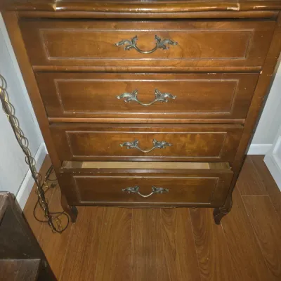 Sale Photo Thumbnail #13: A French Provincial style wooden chest of drawers featuring four drawers with ornate bronze-tone metal bail pulls and cabriole legs. Shows noticeable edge wear, scratches, and finish loss along the top edge and drawer fronts from prior use. 36x28x18