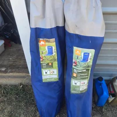 Sale Photo Thumbnail #135: Set of two blue and gray Ozark Trail Air Comfort folding camp chairs in their original carrying bags. Features built-in self-inflating cushions and cup holders. Shows light wear/soil on the outer storage bags from storage.