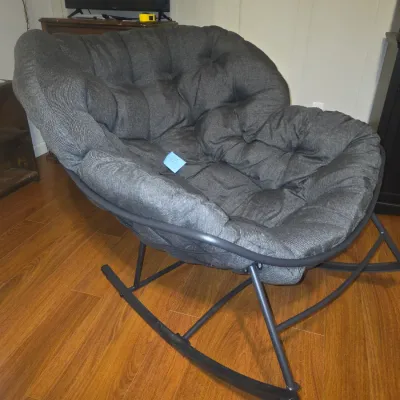 Sale Photo Thumbnail #15: Modern oversized papasan-style rocking chair featuring a dark metal frame and a thick, tufted dark gray fabric cushion. Lightly used condition with no visible tears or major wear. Offers comfortable, saucer-style seating with a smooth rocking motion.