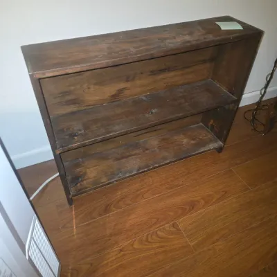 Sale Photo Thumbnail #11: Small dark stain wooden bookcase featuring two open shelves and a top surface. Displays light surface wear, dust, and minor scuffing from use. 24x30x8