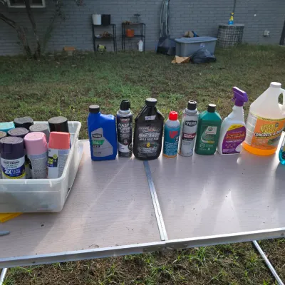 Sale Photo Thumbnail #170: Collection of various household, garage, and automotive liquids and sprays arranged on a table. Includes Krud Kutter concrete cleaner, Rain-X Spot Free car wash, Purple Power degreaser, Castrol GTX motor oil, SuperTech engine degreaser, wasp & hornet kill