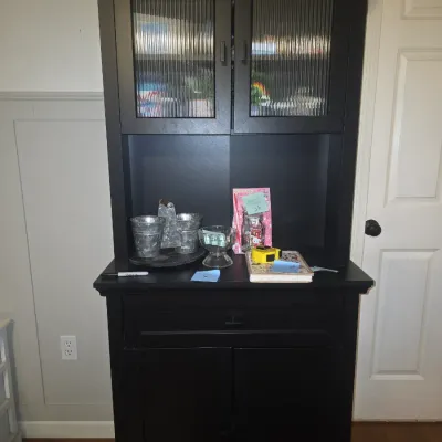 Sale Photo Thumbnail #27: 71x29x16 Modern black painted wooden hutch / storage cabinet featuring upper double doors with ribbed/reeded glass panels, an open center counter section, a pull-out drawer, and lower double storage doors. Shows light wear consistent with use. Contents sh