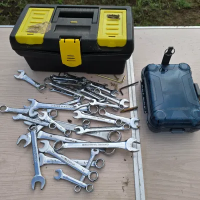 Sale Photo Thumbnail #157: Includes a black and yellow plastic Stanley toolbox with top organizers, a small blue translucent hard case, and an assortment of open-end and combination wrenches in various sizes (including Pittsburgh and Chrome Vanadium brands). Items show signs of lig
