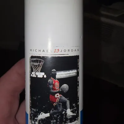 Sale Photo Thumbnail #185: Assorted sports gear lot including a Wilson NCAA football, a Spalding basketball, and a rolled Michael Jordan Chicago Bulls poster in its protective tube. Items show light wear consistent with use.