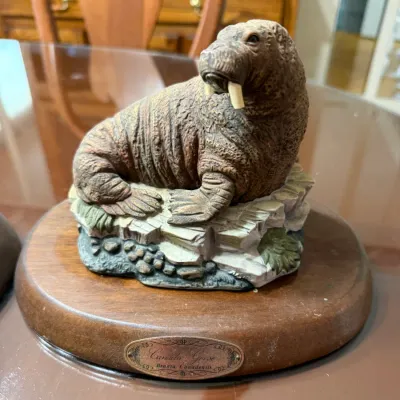 Sale Photo Thumbnail #249: Detailed resin or composite figurine of a walrus on an oval wooden base with a metal nameplate.