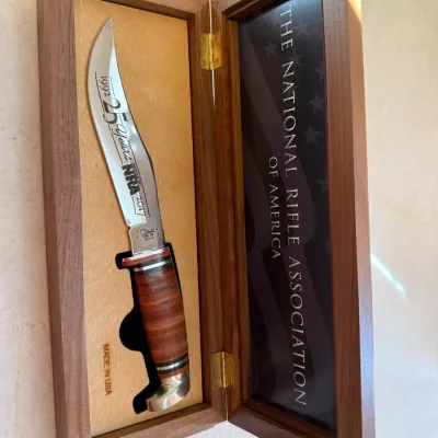 Sale Photo Thumbnail #185: Commemorative NRA 25th Anniversary fixed-blade hunting knife with stacked leather handle in a fitted wooden display box.