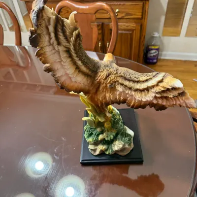 Sale Photo Thumbnail #263: Hand-painted porcelain or resin eagle statue featuring detailed outstretched wings mounted on a black square base.