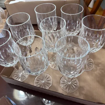 Sale Photo Thumbnail #312: Set of eight crystal wine goblets with diamond cut details and starburst bases, presented in a cardboard packing box.