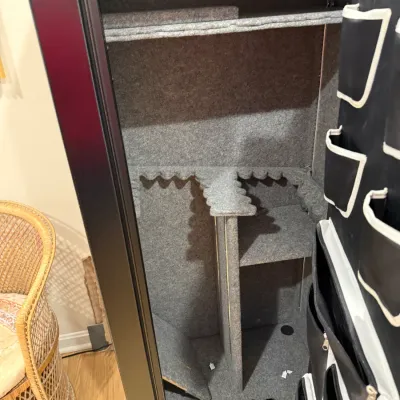 Sale Photo Thumbnail #371: Large black gun safe with carpeted interior shelving, rifle racks, and door storage pockets.