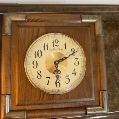 Sale Photo Thumbnail #359: Vintage New Haven quartz wall clock featuring a square wood frame with metal corner accents and decorative black hands.